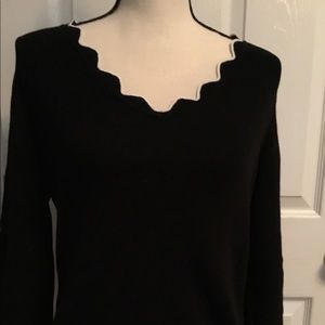 ROZ & ALI knit long sleeved black sweater with white ruffle stitch trim.